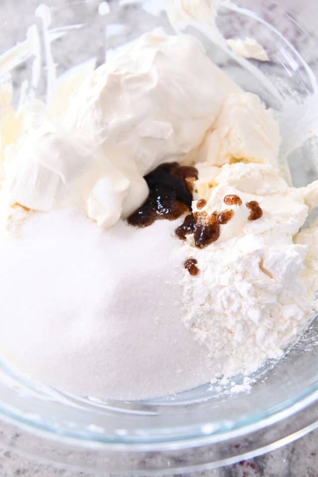 Sugar, cream cheese, cornstarch and vanilla bean paste in glass bowl.