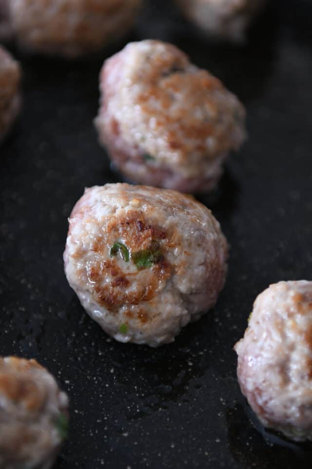 Cooked meatball in skillet.