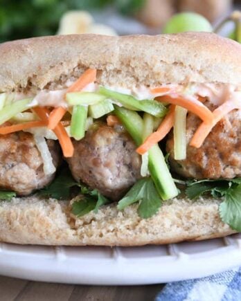 Banh mi meatball sub on cream plate.