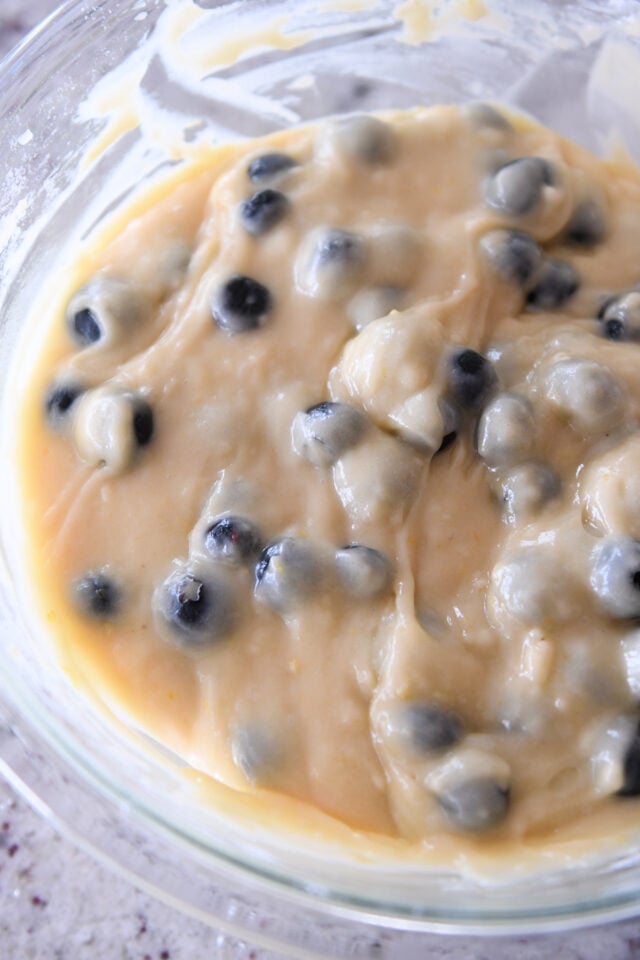 Blueberry muffin batter in a glass bowl.