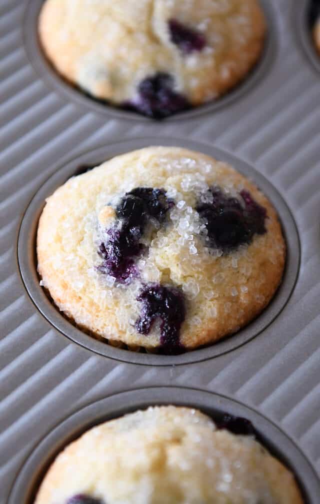 Baked blueberry muffin in a muffin tin.