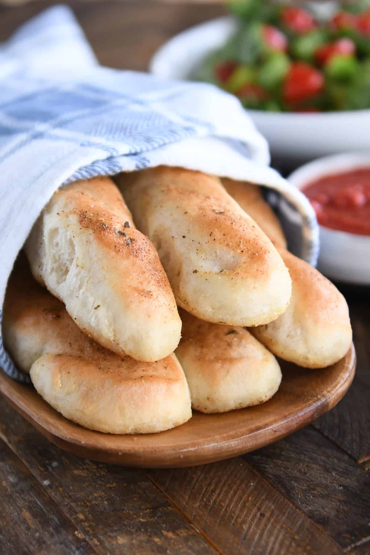 Five breadsticks in white and blue towel.