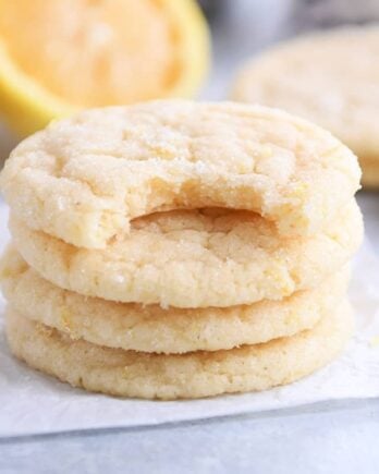 Three and a half stacked lemon sugar cookies on parchment paper.