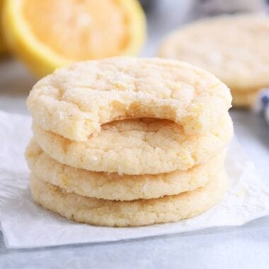 Three and a half stacked lemon sugar cookies on parchment.