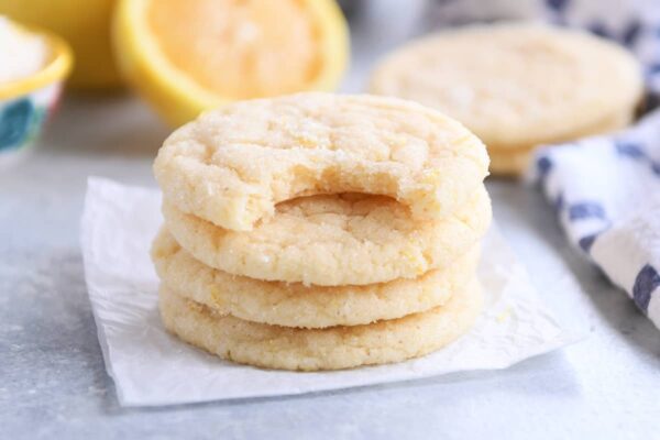 Three and a half stacked lemon sugar cookies on parchment paper.