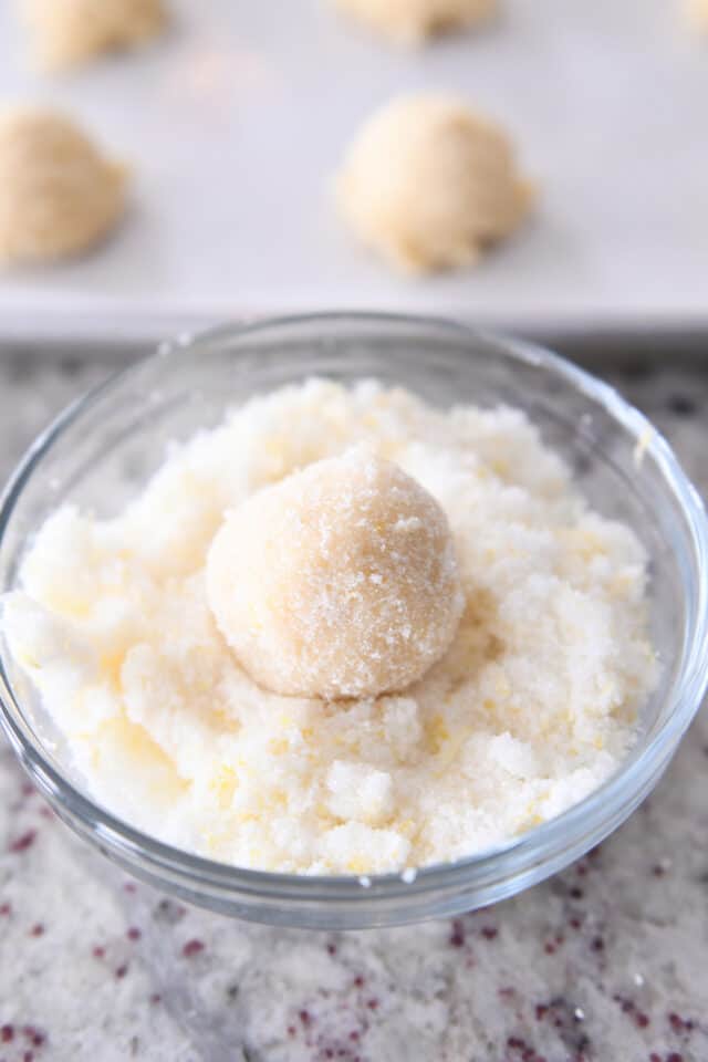 Rolling sugar cookie ball in lemon sugar.