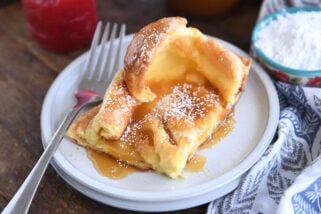 Square of golden German pancake on white plate.