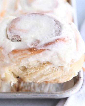 Frosted cinnamon roll on spatula.
