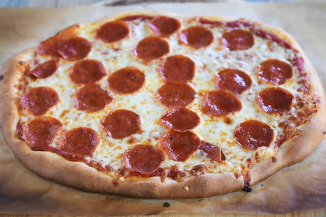 Baked pepperoni pizza with golden crust on parchment paper.