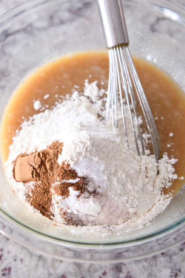 Flour, cinnamon and salt in glass bowl with cake batter.