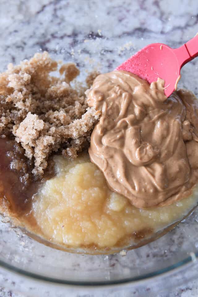 Brown sugar, applesauce, oil, and peanut butter in glass bowl.