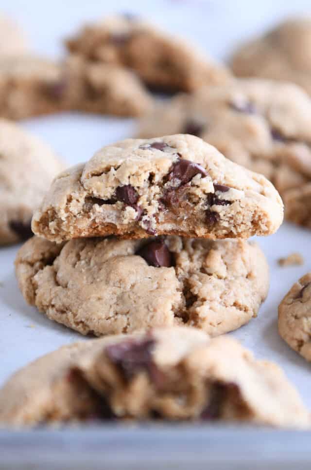 Half cookie on top of whole cookie on half sheet pan.