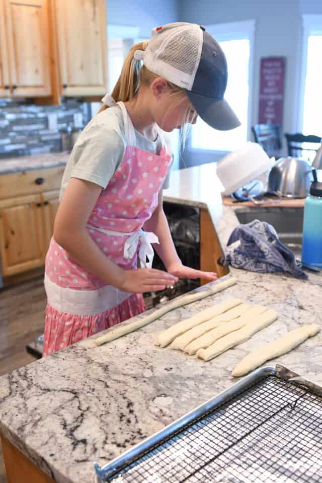 Young girl making pretzels.