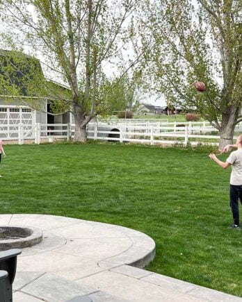 Two kids playing football in back yard