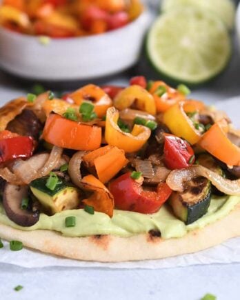 Flatbread topped with creamy avocado sauce and roasted vegetables.