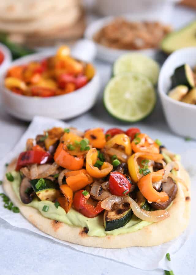 Flatbread with creamy avocado sauce and roasted vegetables.