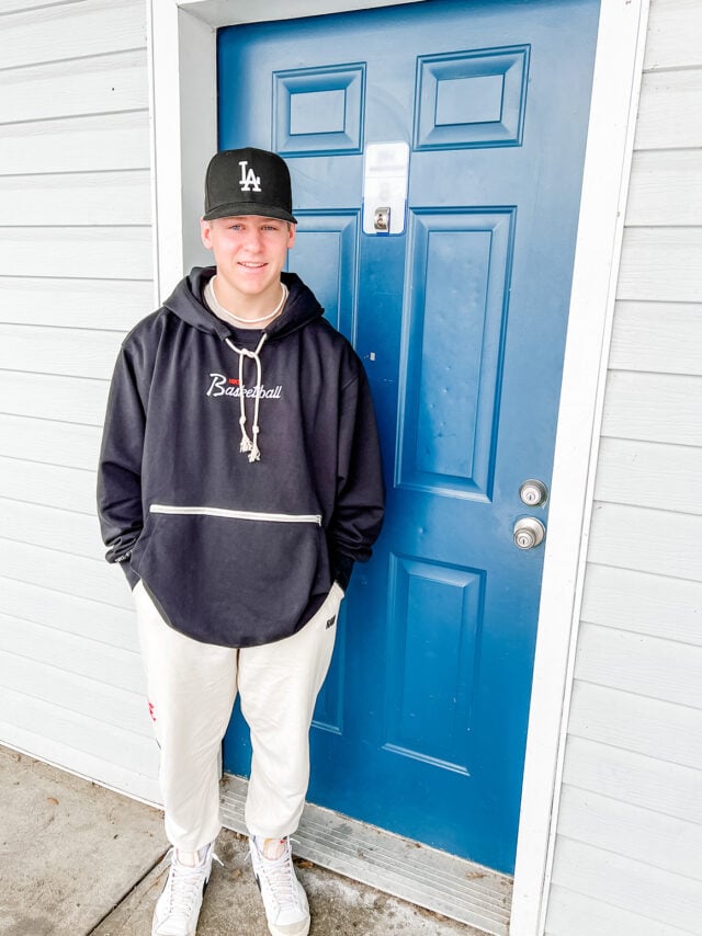 College kid standing outside apartment.