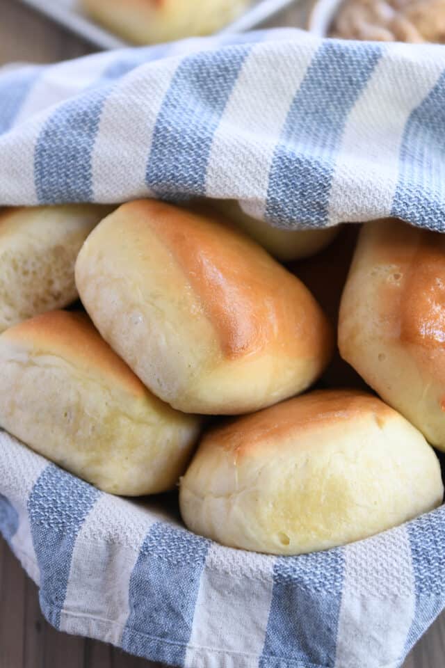 Square roll with other rolls in basket with towel.