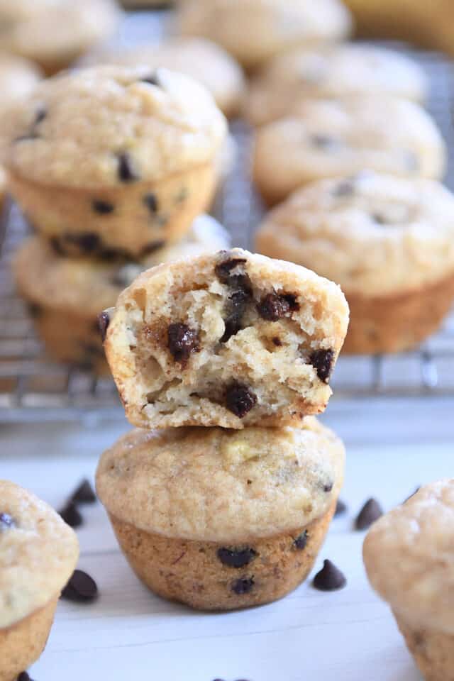Two mini muffins stacked with top muffin in half.