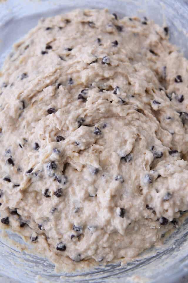 Banana chocolate chip muffin batter in glass bowl.