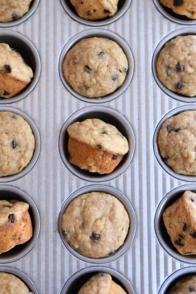 Mini muffins in muffin tin, several of them turned sideways.