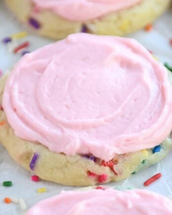 Pressed sugar cookie with sprinkles and pink frosting.