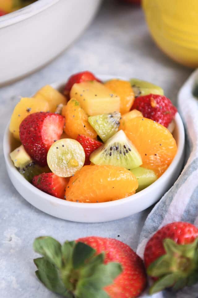 Small white dish with kiwi, grapes, mandarin oranges, and strawberries.