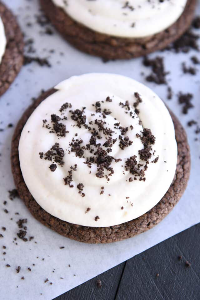 Top down view of chocolate Oreo cookie with white frosting and Oreo cookie crumbs.