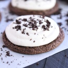 Chocolate cookie with white frosting and Oreo cookie crumbs.