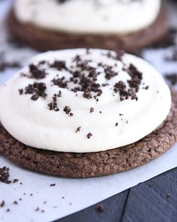 Chocolate cookie with white frosting and Oreo cookie crumbs.