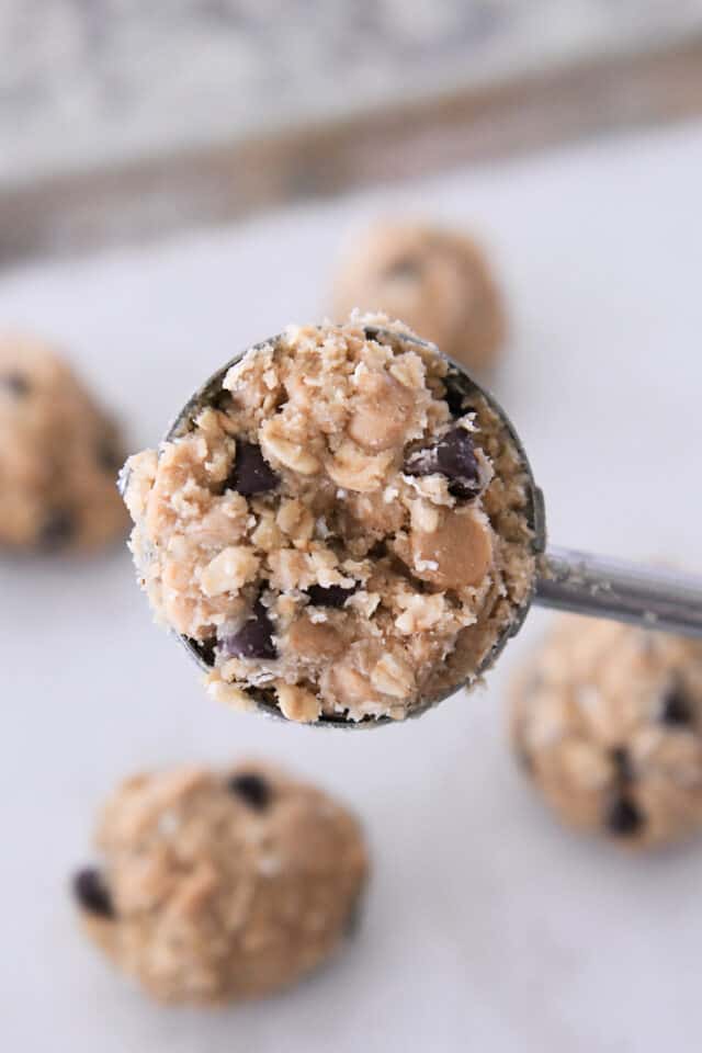 Cookie scoop filled with oatmeal chocolate chip cookie dough with peanut butter chips and toffee bits.