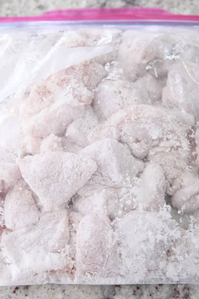 Chicken pieces coated in cornstarch in ziploc bag.