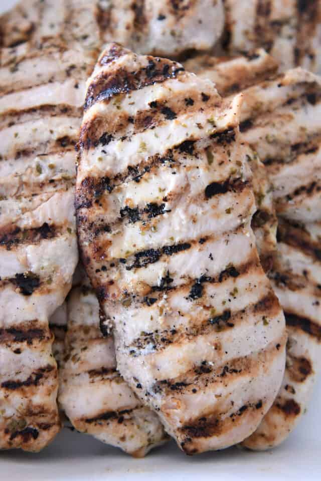 Grilled chicken breasts in white dish.