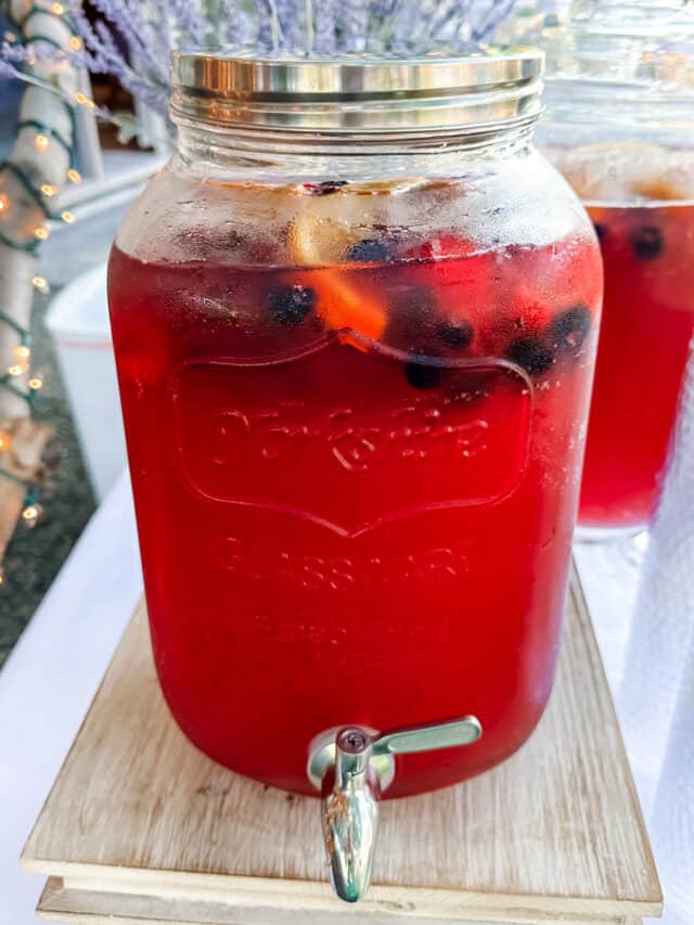 Two gallon drink dispenser with red party punch and berries.