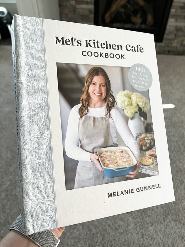 Cookbook cover with author holding a pan of cinnamon rolls.