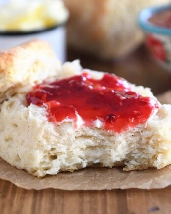 Half of a biscuit with butter and jam.