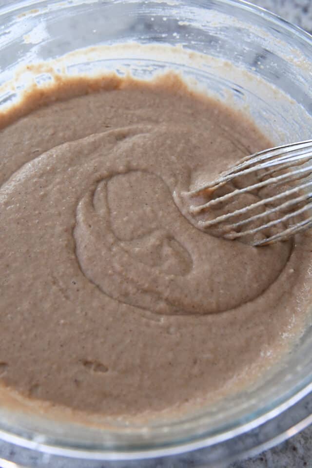 Glass bowl with applesauce spice cake batter.