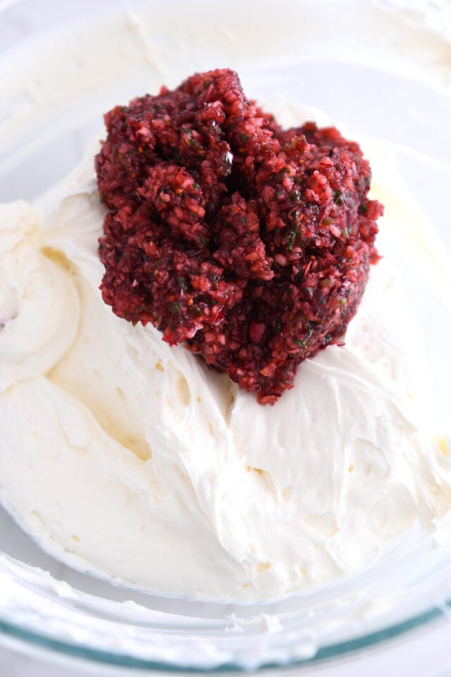 Gl، bowl with whipped cream cheese and a scoop of fresh cranberry jalapeno relish on top.