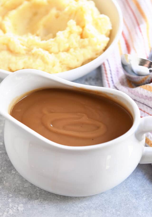 Gravy boat filled with brown gravy.