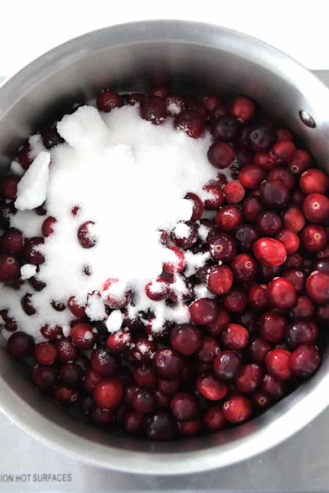 Saucepan with fresh cranberries and sugar.