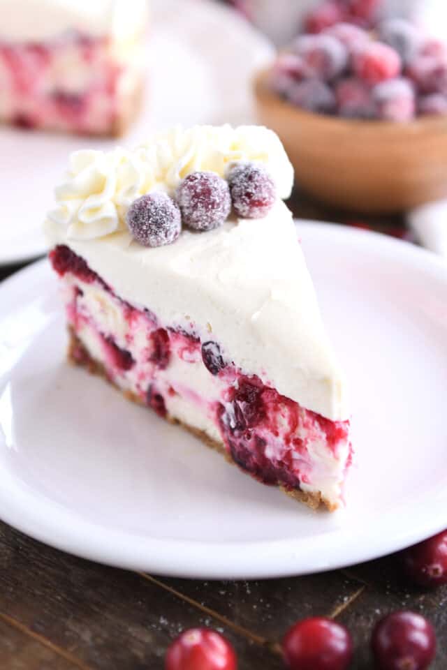 Slice of cranberry cheesecake on white plate.