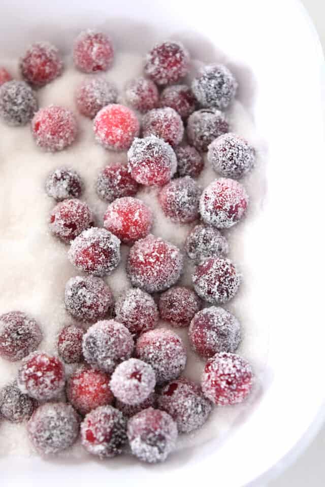 Cranberries rolled in sugar in white dish.