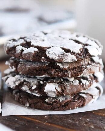 Four chocolate crinkle cookies stacked.