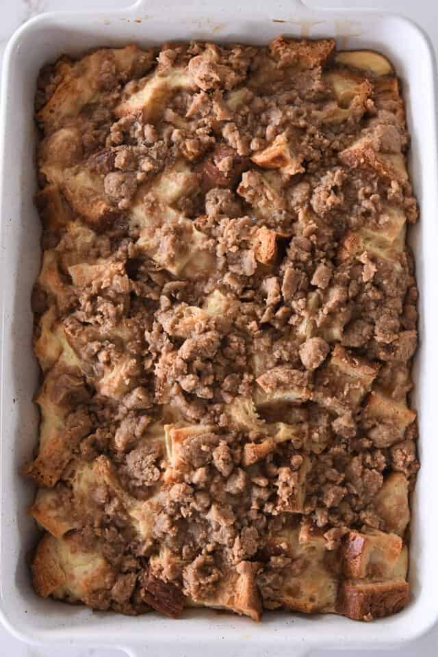 White pan with baked bread cubes for French toast bake and cinnamon streusel.