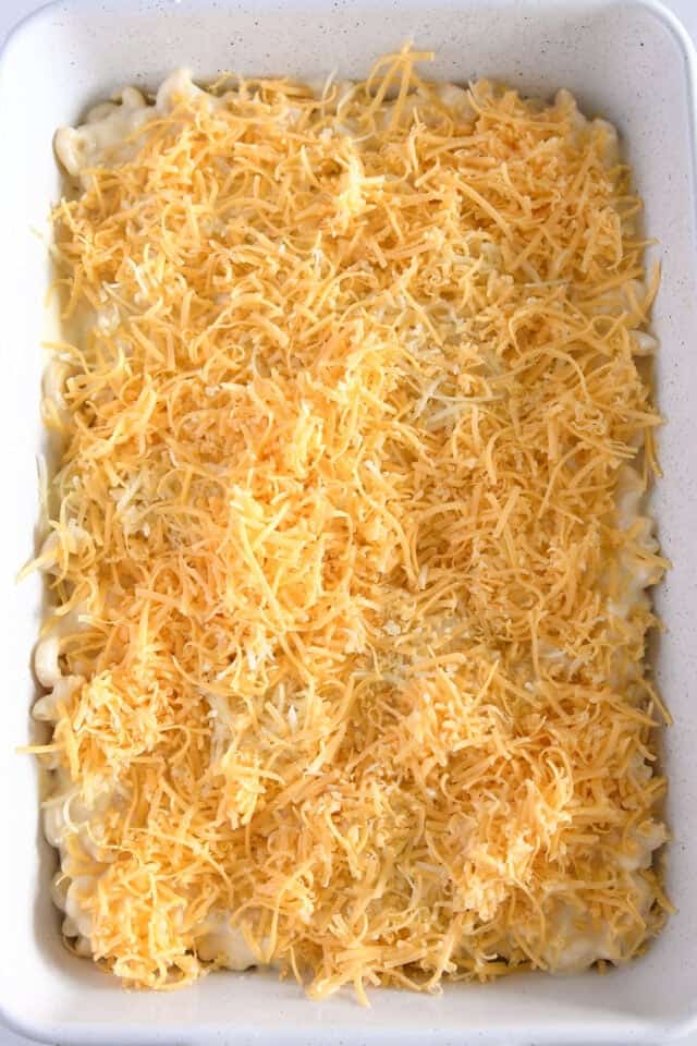 Top down view of assembled macaroni and cheese with shredded cheese.