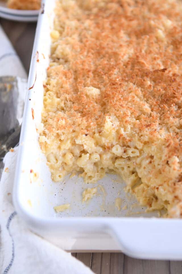 Serving pan of baked macaroni and cheese with one serving removed.