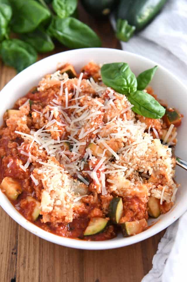 Serving of Italian chicken zucchini skillet meal in white bowl.