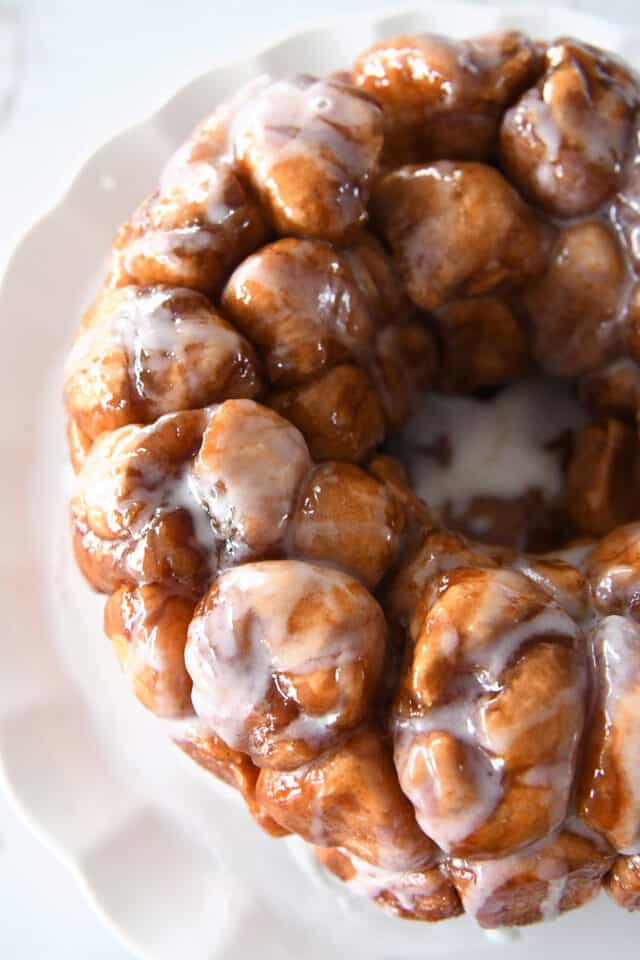 Top down view of pull-apart monkey bread with glaze on white tray.