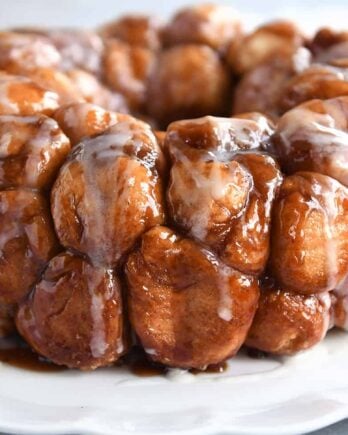 Monkey bread turned out onto white tray and glazed.