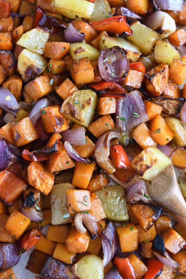 Roasted potatoes, red onions, red bell peppers and butternut squash on sheet pan.